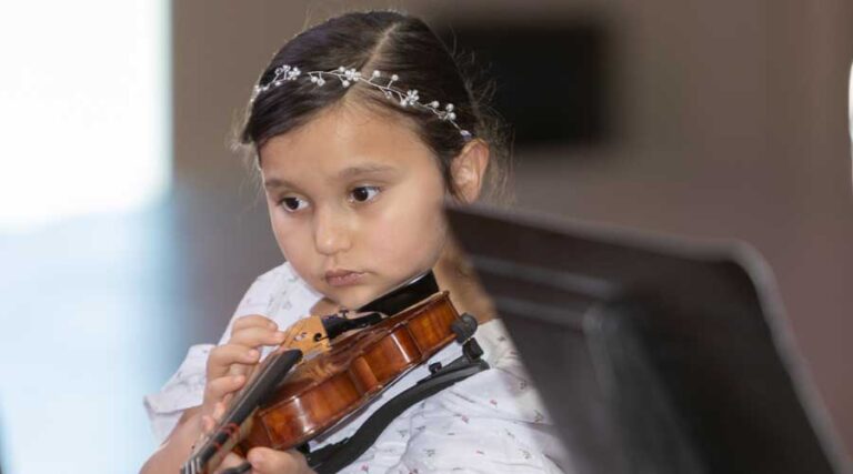 A young musician plays her instrument.